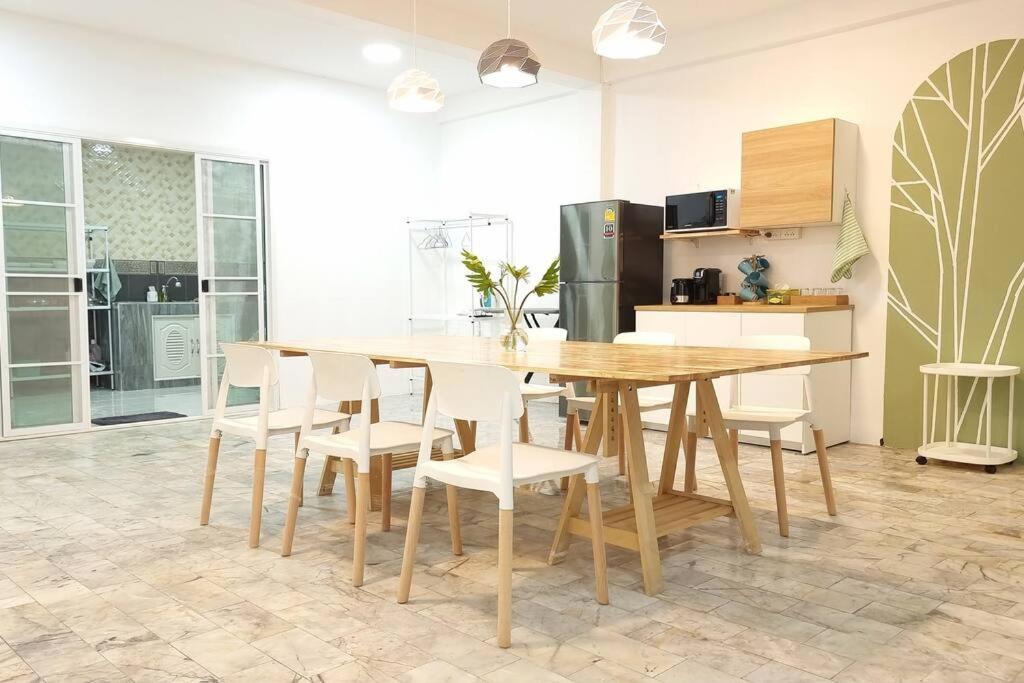 een keuken met een houten tafel en witte stoelen bij Eco-friendly house near street food quiet area in Chiang Mai