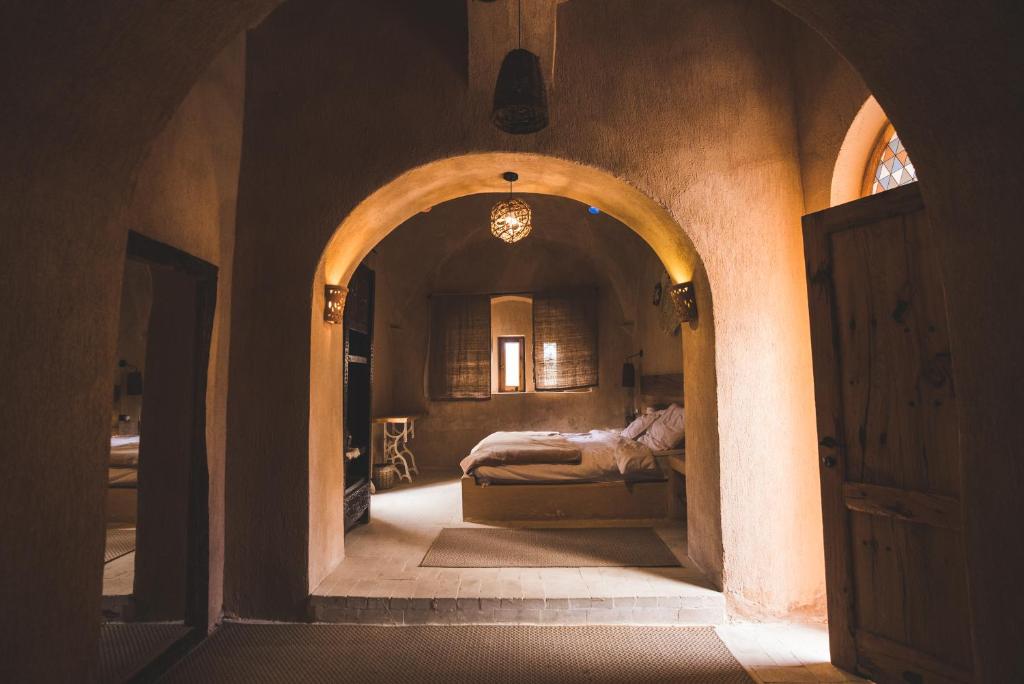 - une chambre avec un lit dans un couloir voûté dans l'établissement Tzila Lodge, à Fayoum