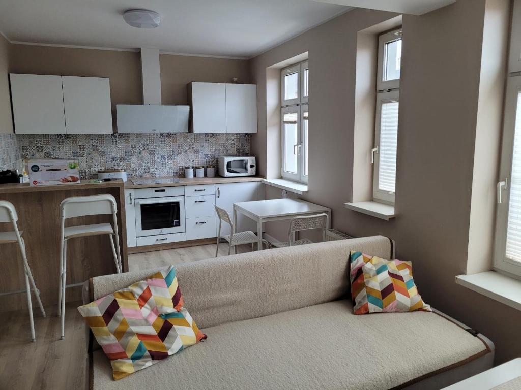uma sala de estar com um sofá e uma cozinha em Apartament na Wąskiej em Bydgoszcz