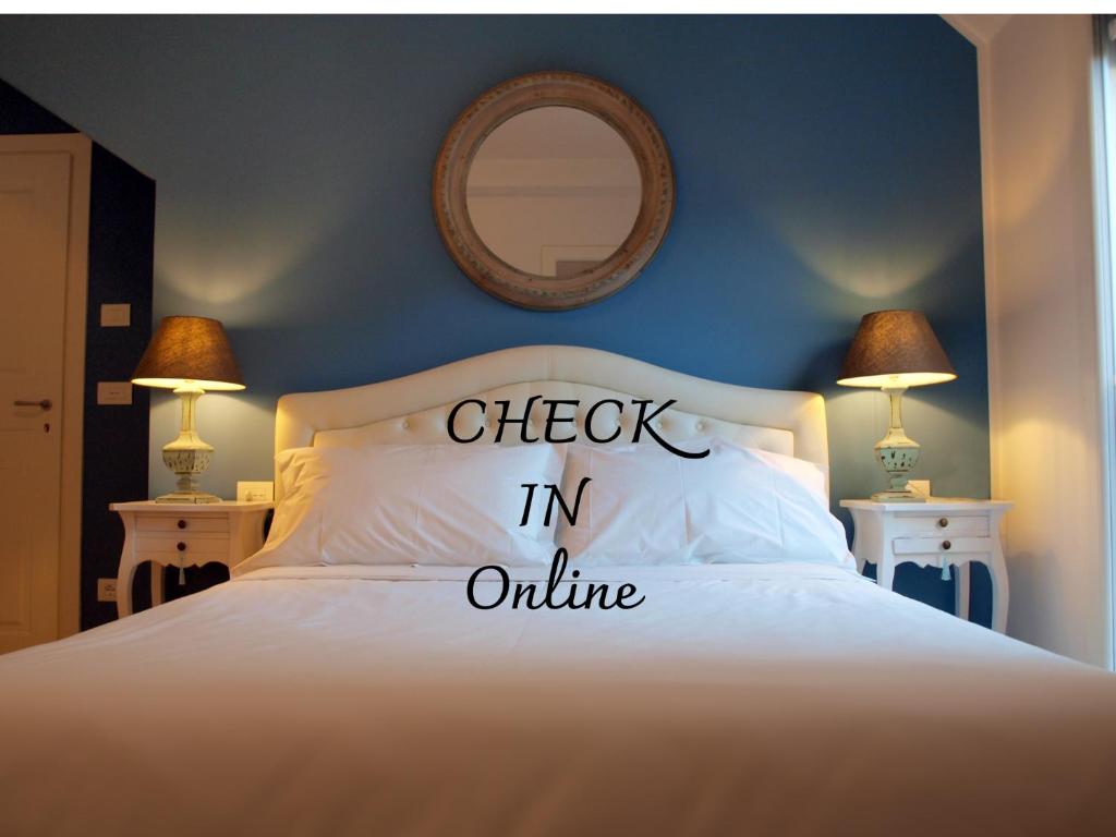 a bed with the words check in online written on it at Cosmopolitan Central Rooms in Bologna