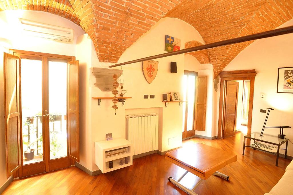 sala de estar con suelo de madera y pared de ladrillo en Merville House en Florencia