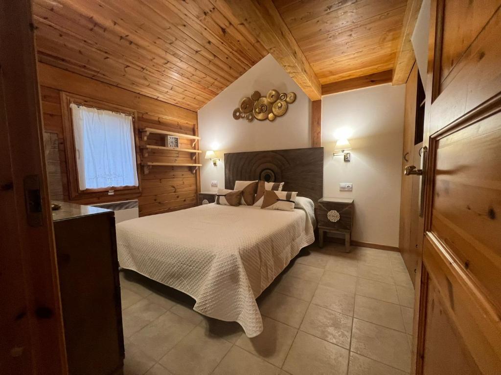 a bedroom with a bed in a room with wooden walls at Cabaña de madera Vall D Incles Parking y Wifi Gratis in Incles