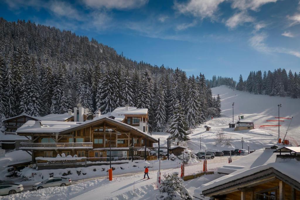 un lodge de ski dans la neige en face d'une montagne dans l'établissement Hôtel Les Servages d'Armelle, aux Carroz d'Arâches