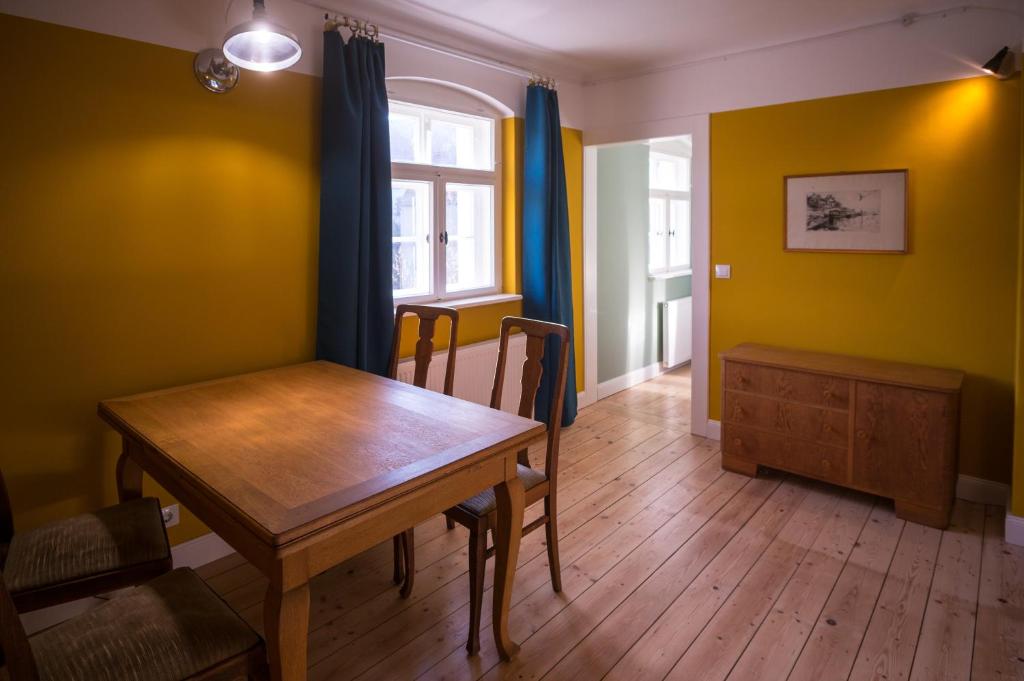 comedor con mesa de madera y paredes amarillas en Holiday in quiet quarter, 20 min to city center, en Dresden