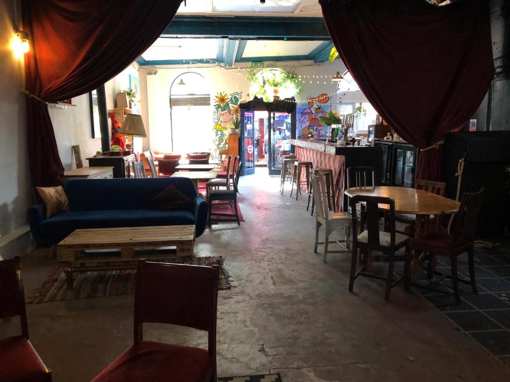 a restaurant with chairs and tables and a blue couch at 2 Bedroom flat on Tottenham High Rd. in London