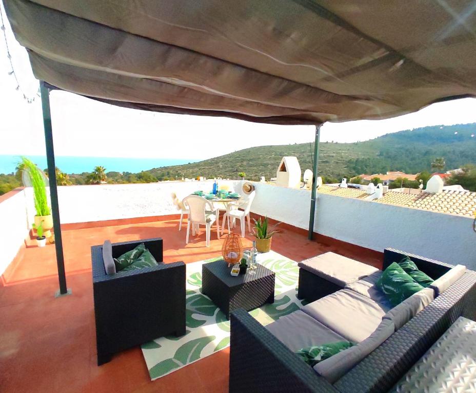 a patio with couches and a table on a roof at La casa de Leones in Peniscola