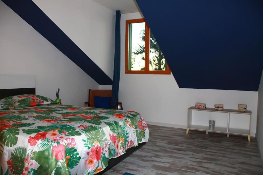 a bedroom with a bed and a window at Ti l'Endormi Villèle Saint Gilles Les Hauts in La Saline