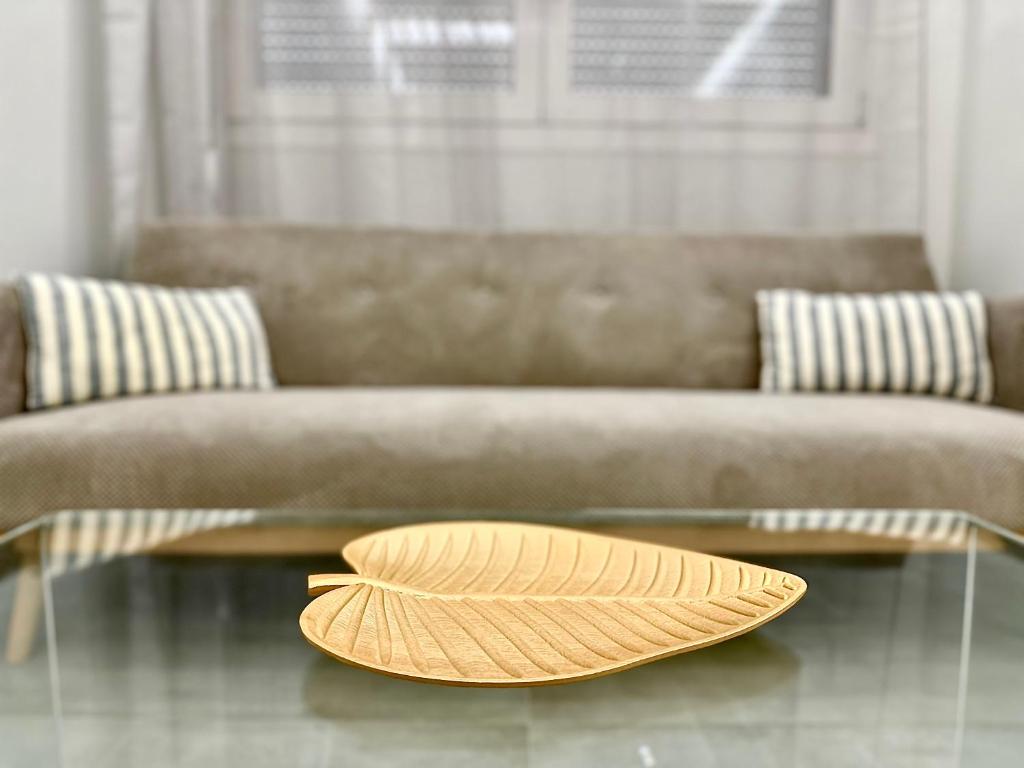 Un cappello seduto su un tavolo di vetro di fronte a un divano di Urban Luxus Studio II a Heraklion