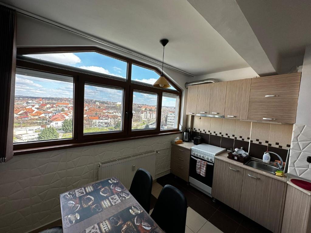 een keuken met uitzicht op de stad door de ramen bij High level Apartament Oradea in Oradea