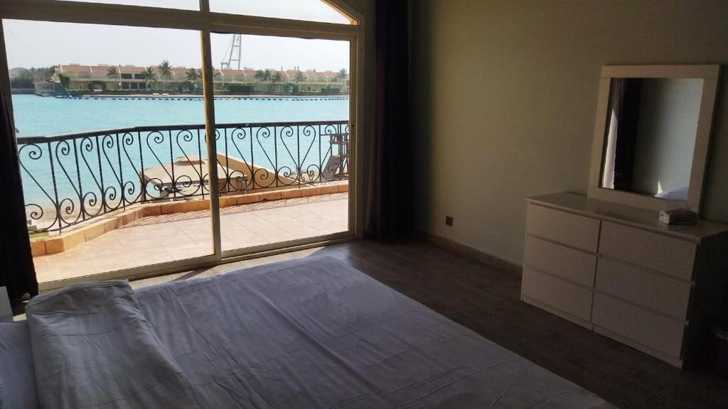a bedroom with a large window with a view of the water at درة العروس كورال بيتش فيلا in Durat Alarous