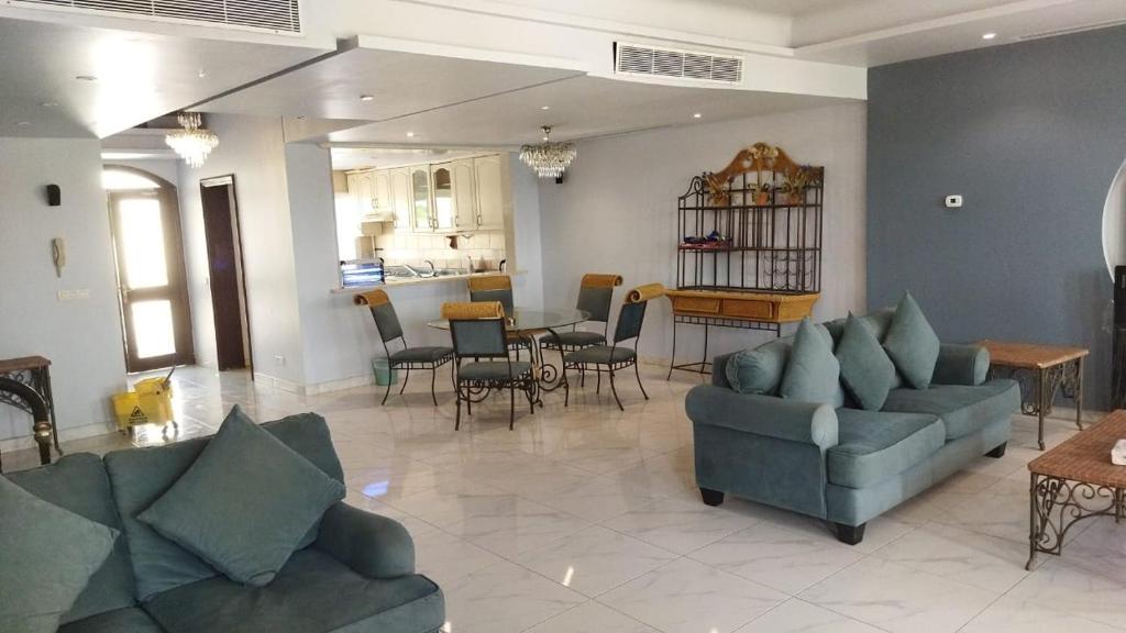 a living room with two couches and a dining room at درة العروس كورال بيتش فيلا in Durat Alarous