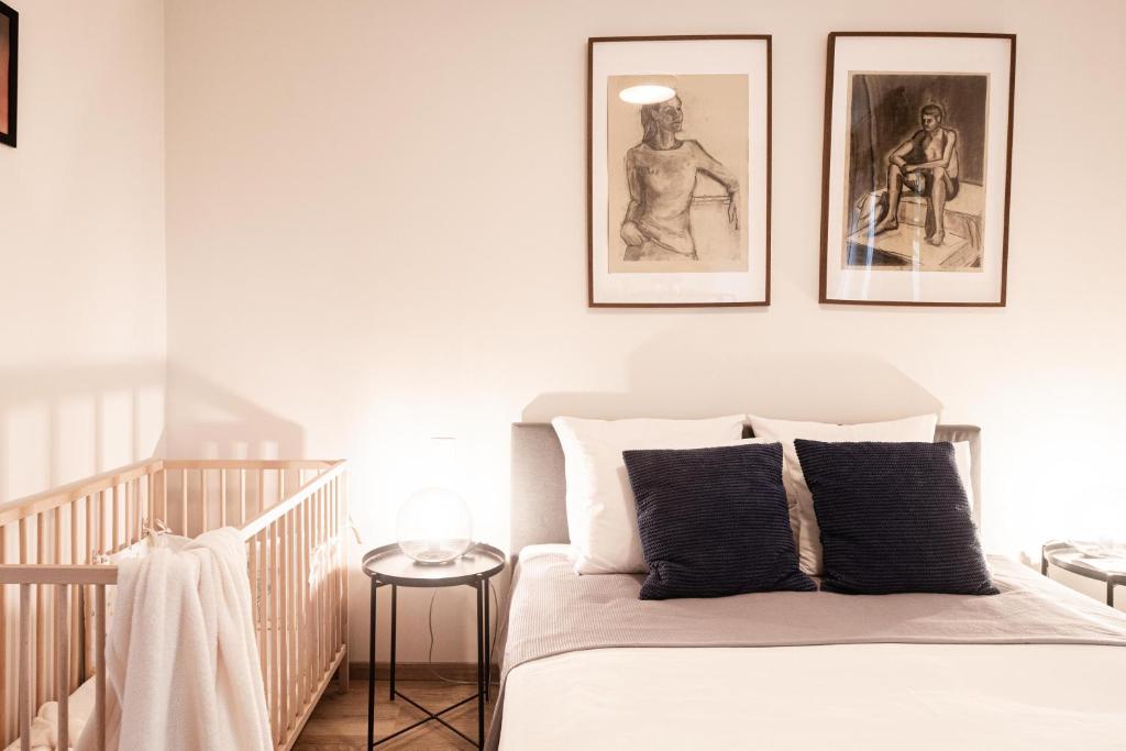 a bedroom with a bed with three pictures on the wall at OAK Residents Siófok in Siófok