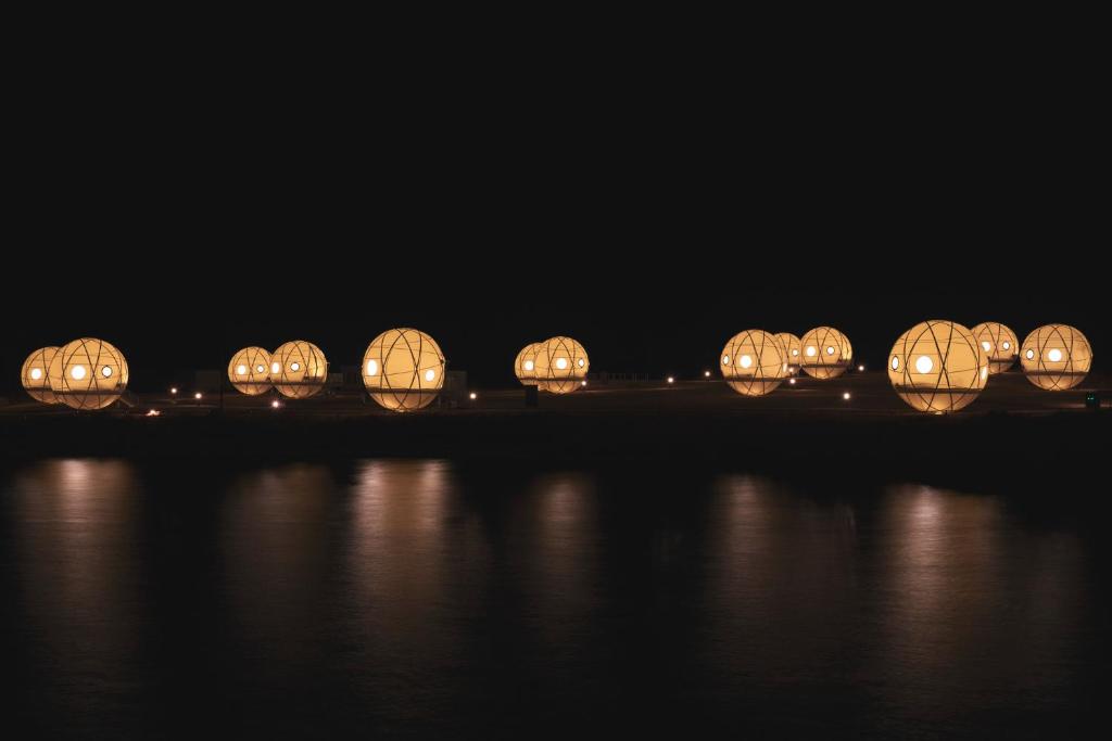 eine Reihe von beleuchteten Lichtern im Wasser in der Nacht in der Unterkunft INN THE PARK Fukuoka in Fukuoka