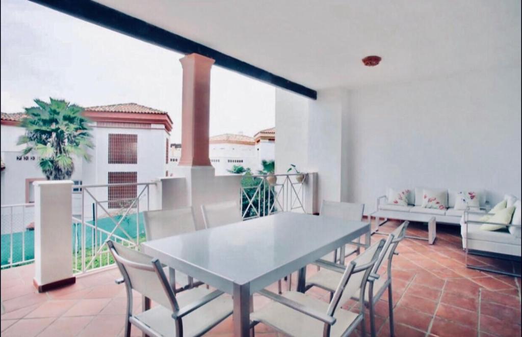jadalnia ze stołem i krzesłami na balkonie w obiekcie Apartamento familiar con JARDIN y TERRAZA Privada w mieście La Alcaidesa