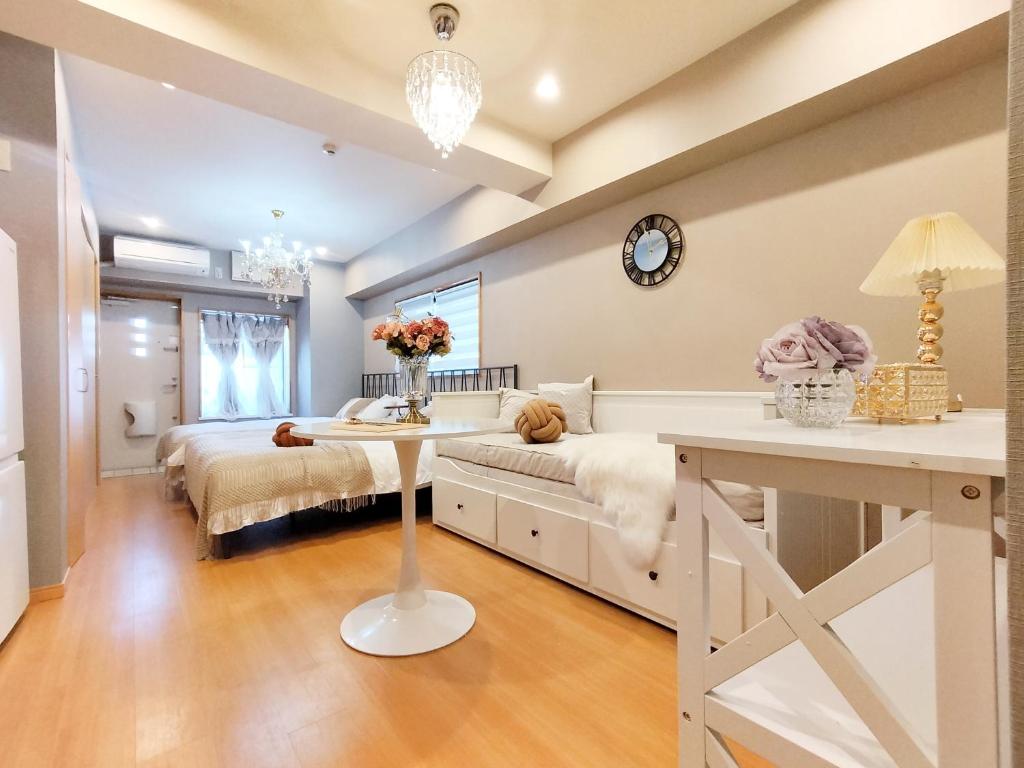 1 dormitorio con 2 camas y una mesa con flores en 15 西新宿区域 家庭式民宿- Nisjishinjuku area Max 6p, en Tokio