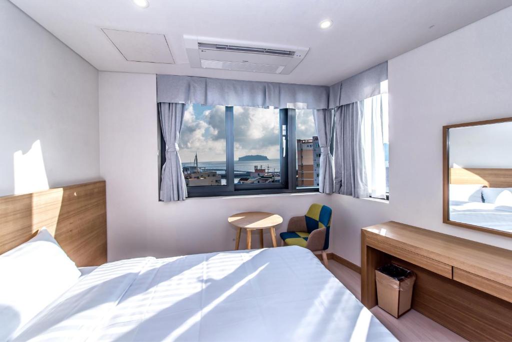 Postel nebo postele na pokoji v ubytování BK Hotel Jeju