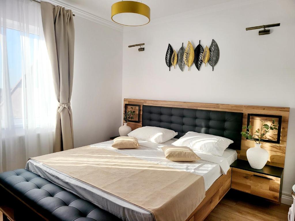 a bedroom with a large bed with a blue bench at Queen Room - House of Chess in Satu Mare