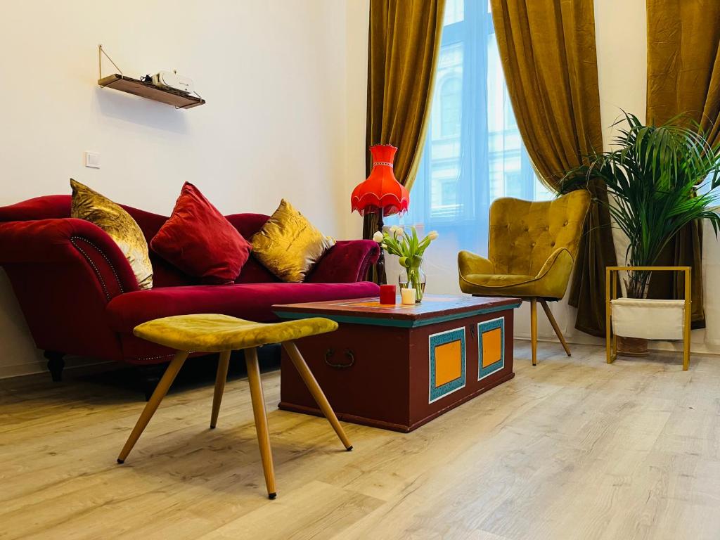 uma sala de estar com um sofá vermelho e uma mesa em FILMAP-Apartments-Zentrale Lage-Boxspringbett-Beamer-Popcorn-gratis Parkplatz em Görlitz