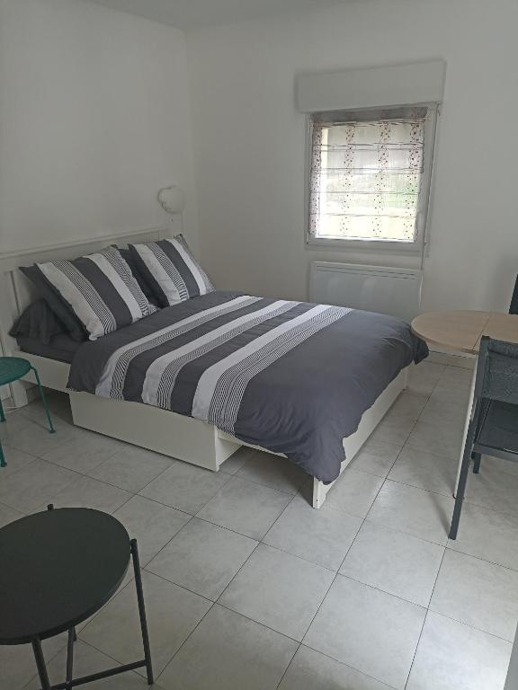 une chambre avec un lit, une table et des chaises dans l'établissement Studio Vacances château Malo saint Malo, à Saint-Malo