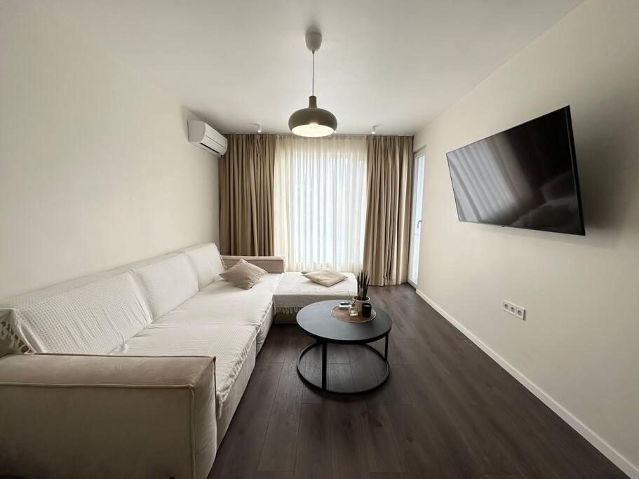 a living room with a white couch and a table at New luxury furnished apartment - beach, Varna center & fast Wi-FI in Varna City