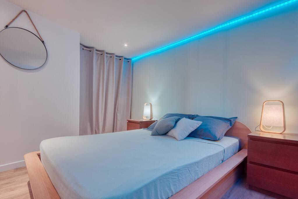 a bedroom with a bed with a blue light on it at Le 002 - T3 climatisé avec terrasse in Marseille