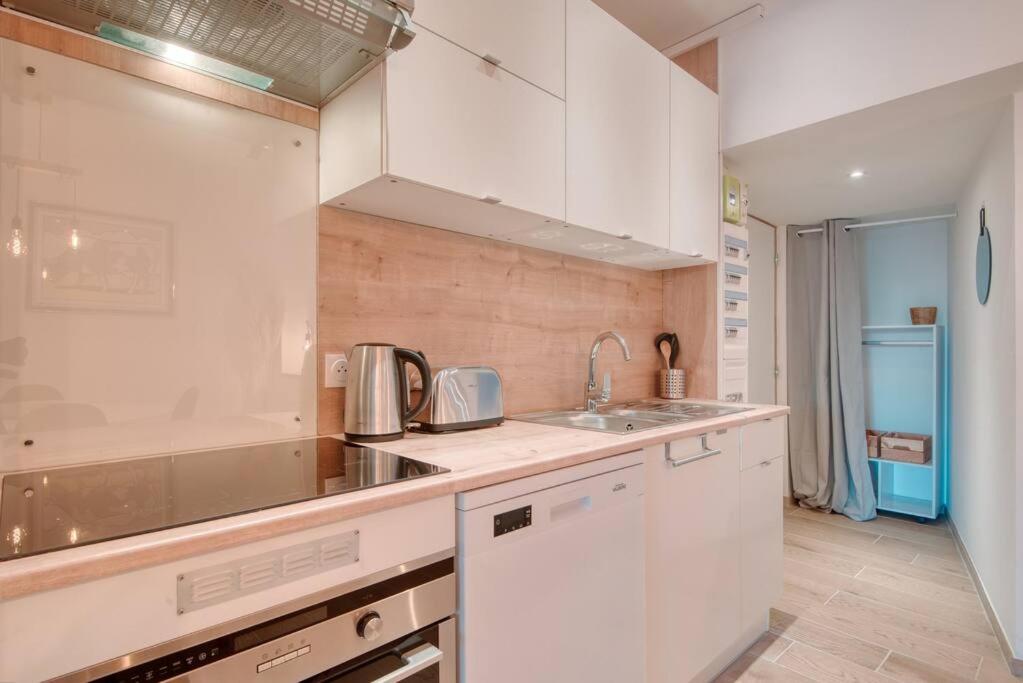 a kitchen with white cabinets and a sink at Le 002 - T3 climatisé avec terrasse in Marseille