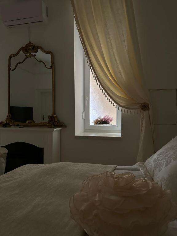 a bedroom with a bed and a mirror and a window at FSF Boutique Apartament in Timişoara
