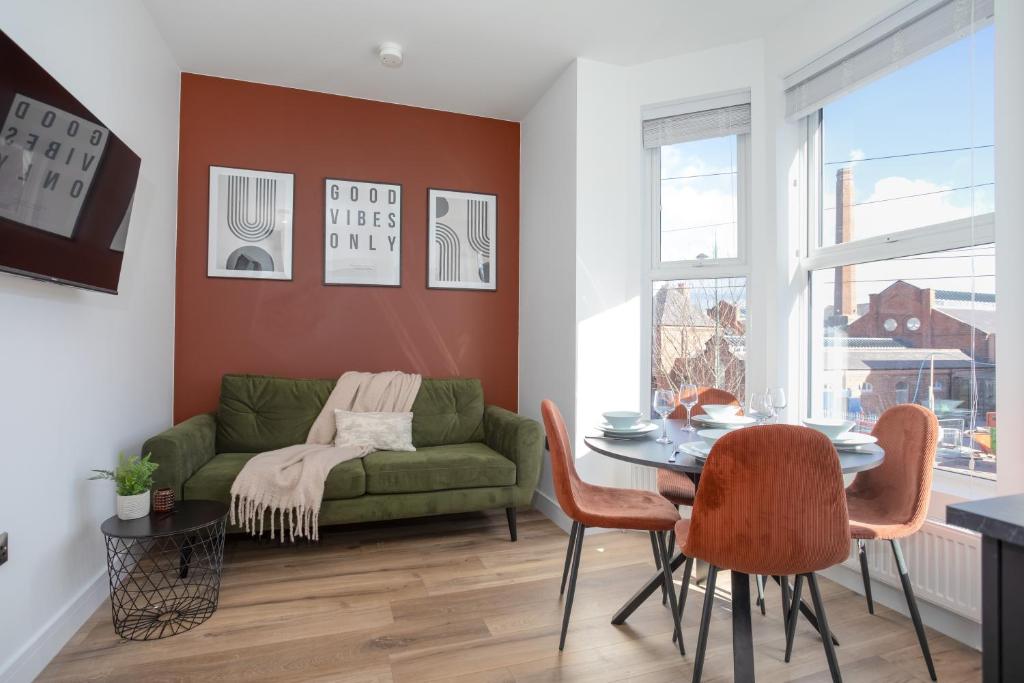 a living room with a green couch and a table at Eastside Capital Apartments in Belfast