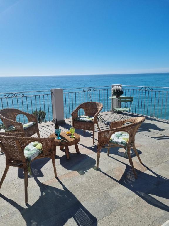 a group of chairs and tables on a patio overlooking the ocean at Agriturismo La Tuffatrice in Imperia