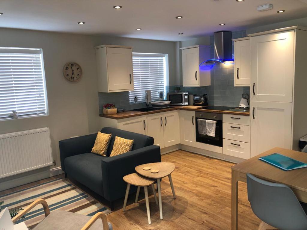 a living room with a couch and a kitchen at Modern 2-Bed House and Parking Tibshelf Derbyshire in Alfreton