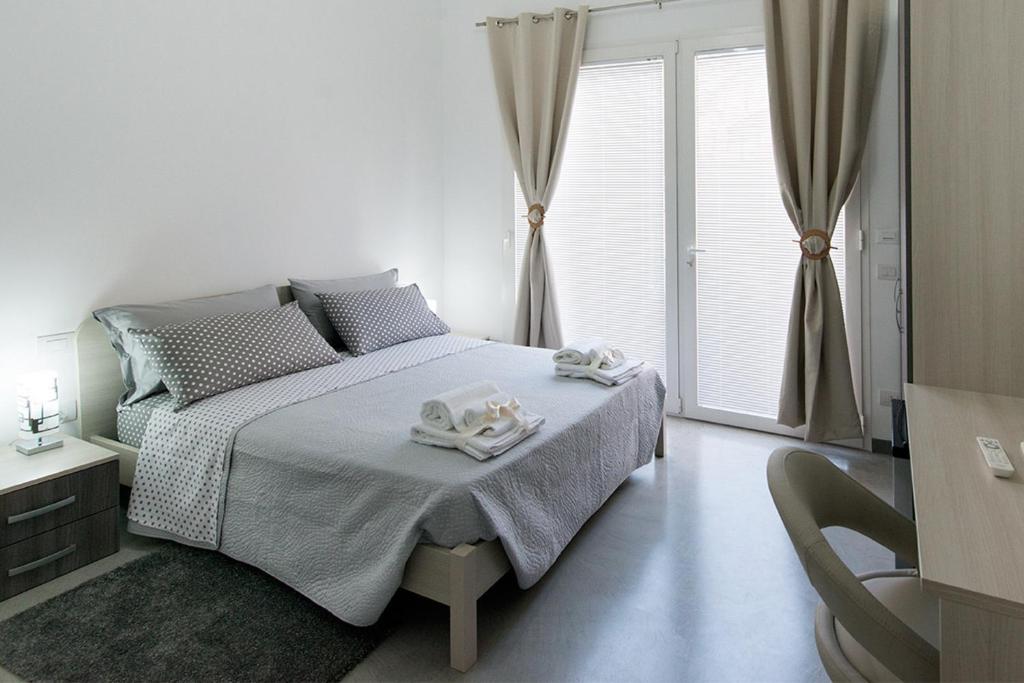 Un dormitorio blanco con una cama con toallas. en Byron Rooms, en La Spezia