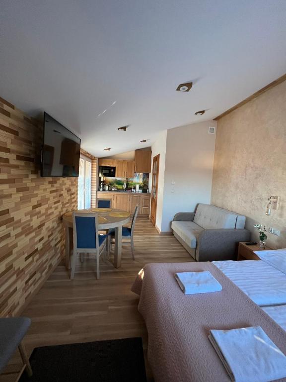 a living room with a couch and a dining room at Apartament Vanessa 2 u podnóża gór, nad jeziorem Czorsztyńskim in Harklowa