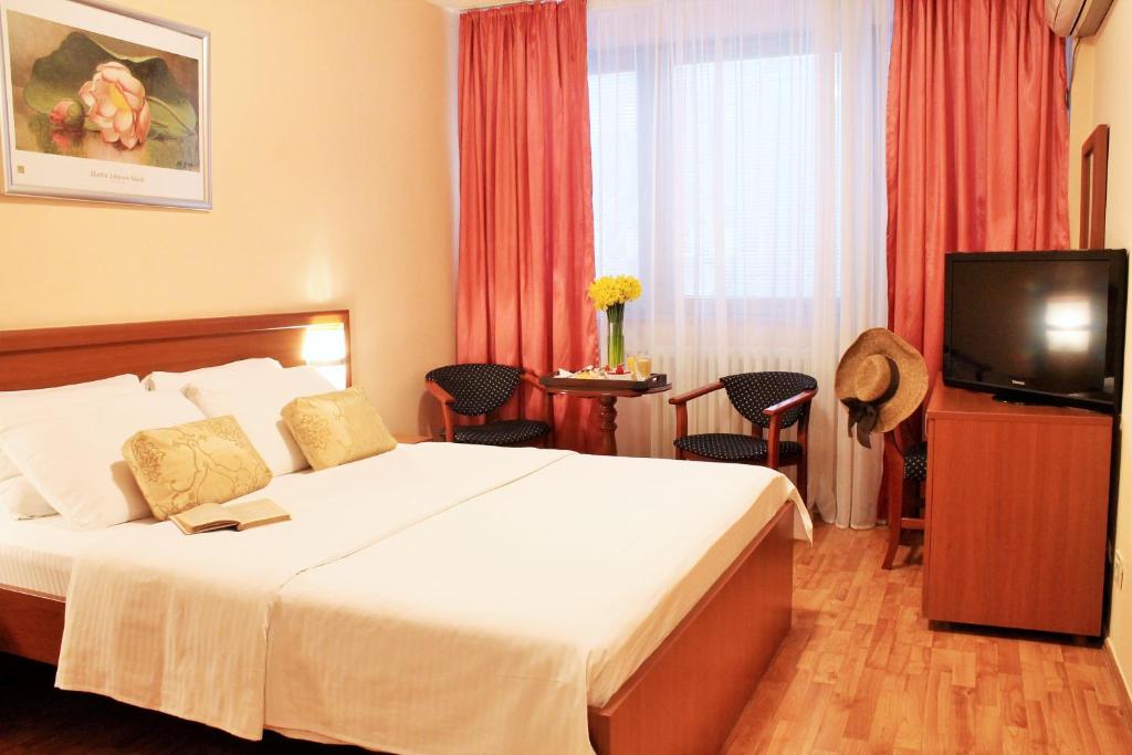 una camera d'albergo con letto e TV di Hotel Rex a Belgrado
