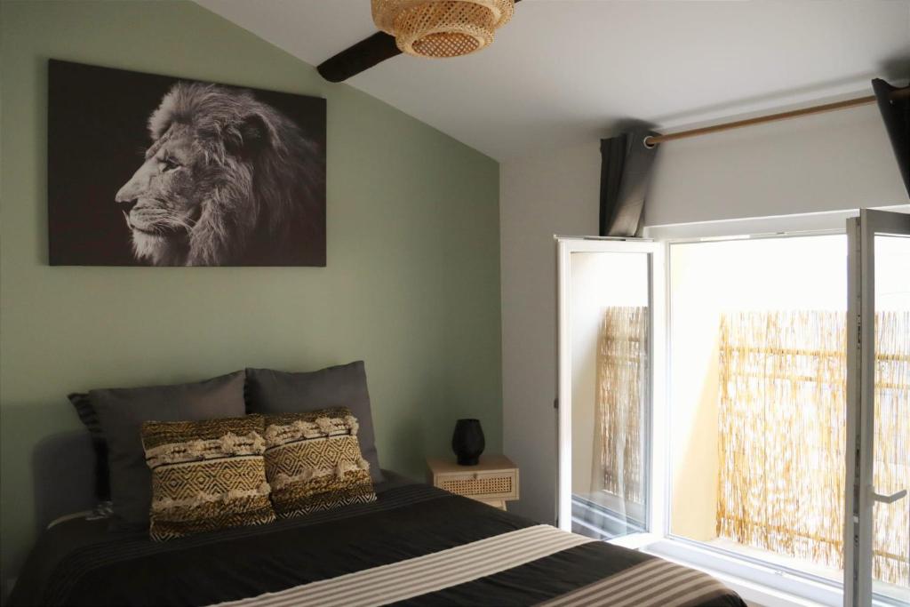 a bedroom with a bed with a lion picture on the wall at Proche d'Uzès la Terrasse du soleil levant in Collias