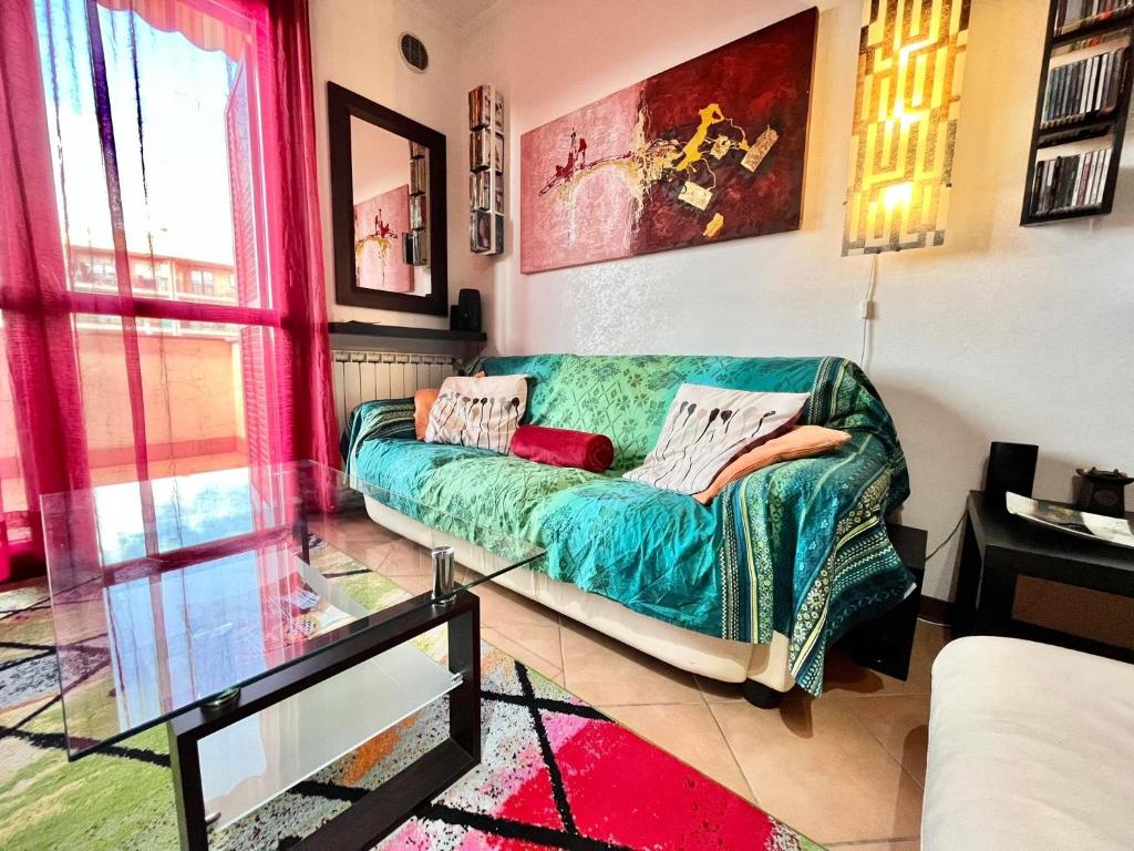 uma sala de estar com um sofá verde num quarto em JAZZ House ROMA! em Infernetto