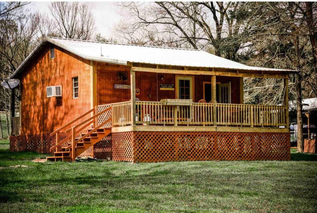 a small wooden house with a porch and a deck at Caddo Cabin on Collier Creek in Norman