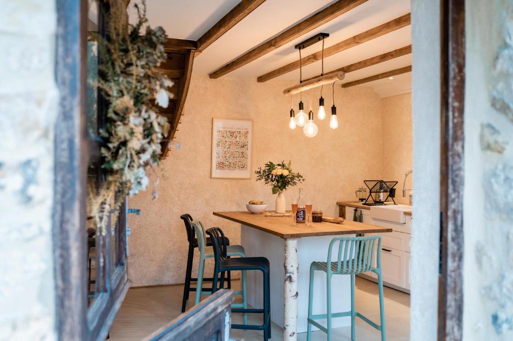 a kitchen with a table and chairs in a room at Cottage Breton - Gîte de Charme en Centre Finistère (Situation idéale) in Plonévez-du-Faou