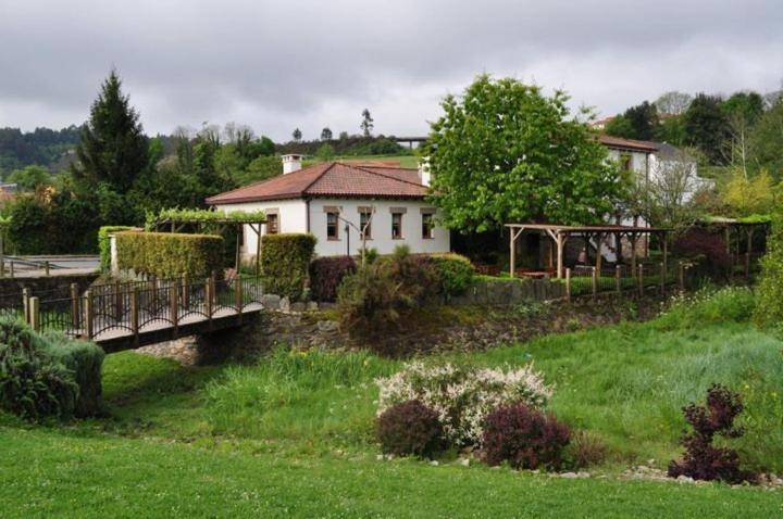 una casa en una colina con un puente sobre un campo en El Balcón del Eume, Cantina Río Covés, en Puentedeume