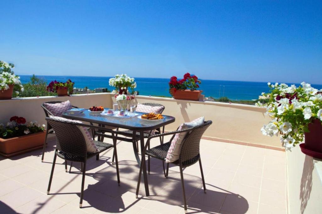 - une table et des chaises sur une terrasse donnant sur l'océan dans l'établissement Theodore Seaview Home, à Sfakaki