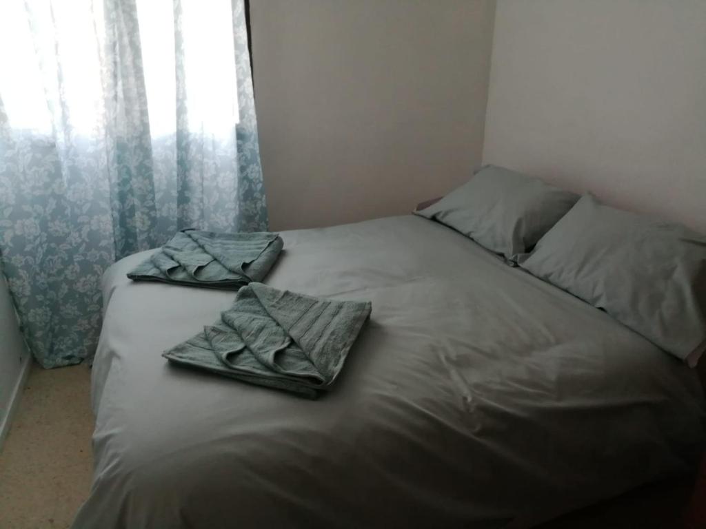 a bed with towels on it in a bedroom at Gibraltar Rock View in La Línea de la Concepción