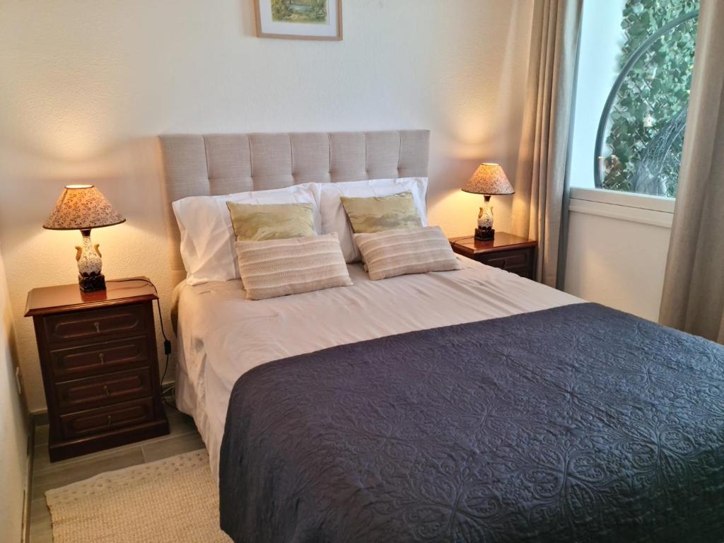 een slaapkamer met een groot bed met 2 lampen bij Desertas View Apartment in Machico