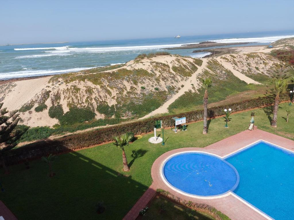 Una vista aérea de una piscina junto a la playa. en Appartement au bord de l'eau, en Mohammedia