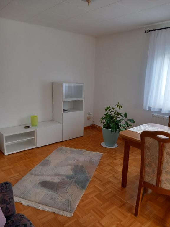 a white living room with a table and a chair at Ferienhaus Carolin in Heidenheim an der Brenz