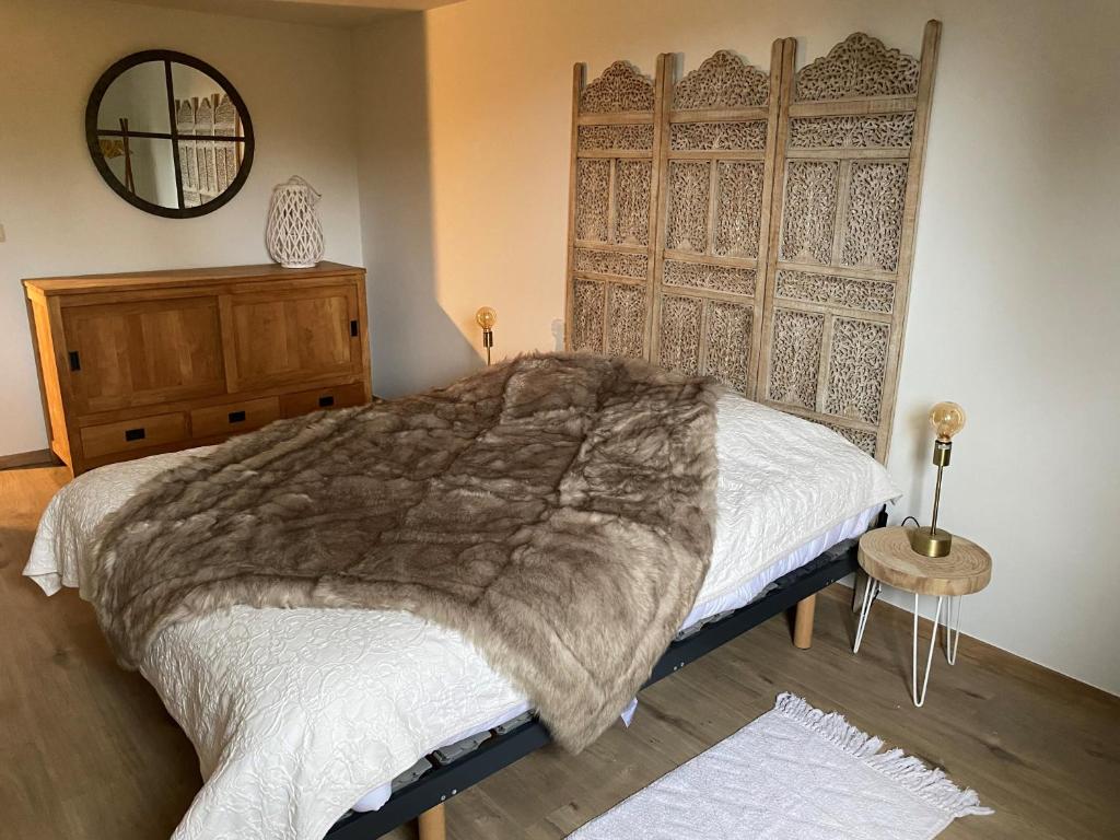 een slaapkamer met een groot bed en een spiegel bij Le logis des Chênes, superbe bungalow dans quartier résidentiel proche de Namur in Wépion