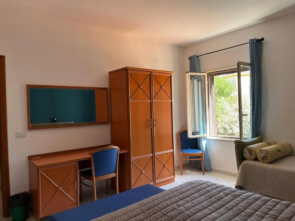 a bedroom with a bed and a desk and a tv at Hotel d'Orleans in Palermo