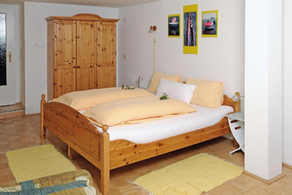 ein Schlafzimmer mit einem großen Holzbett in einem Zimmer in der Unterkunft Gasthof Moser in Fohnsdorf