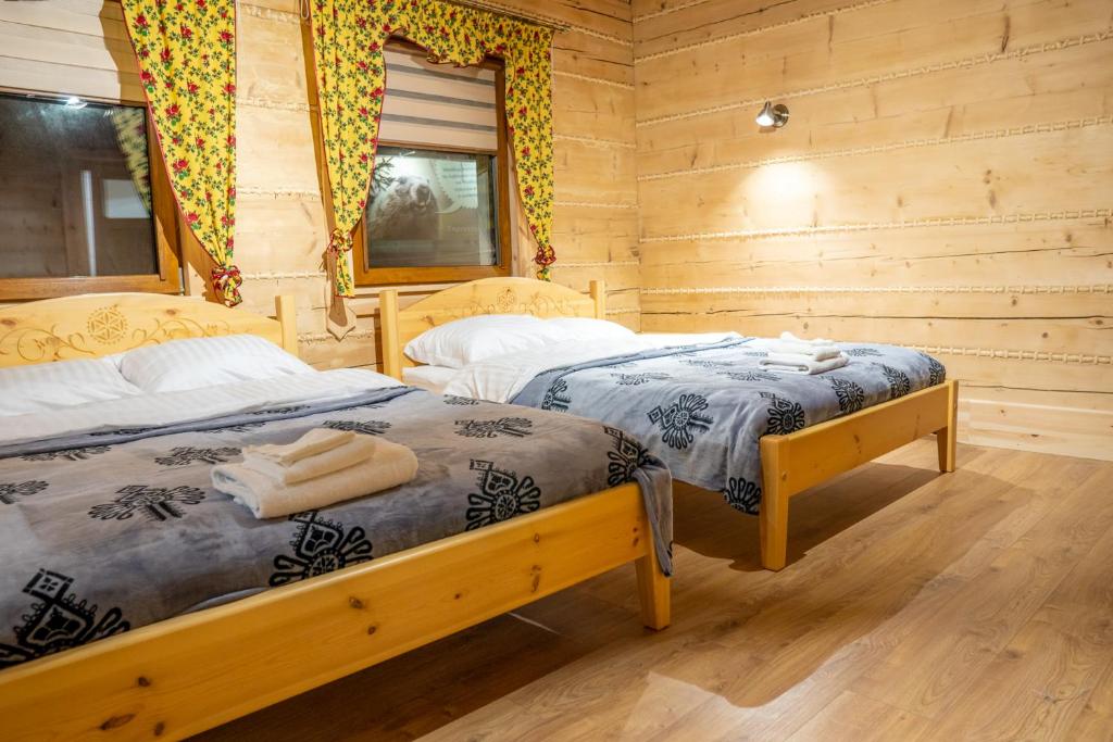 - une chambre avec 2 lits dans une cabane en rondins dans l'établissement Apartamenty Aleksandra, à Gronków