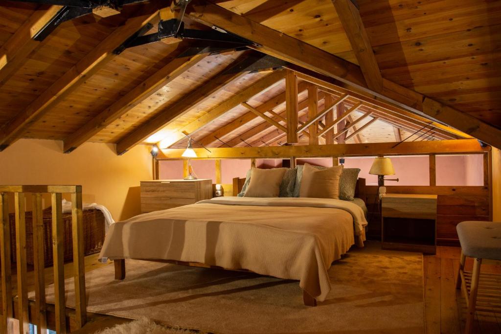 um quarto com uma cama num quarto com tectos em madeira em Passenger Point em Volos