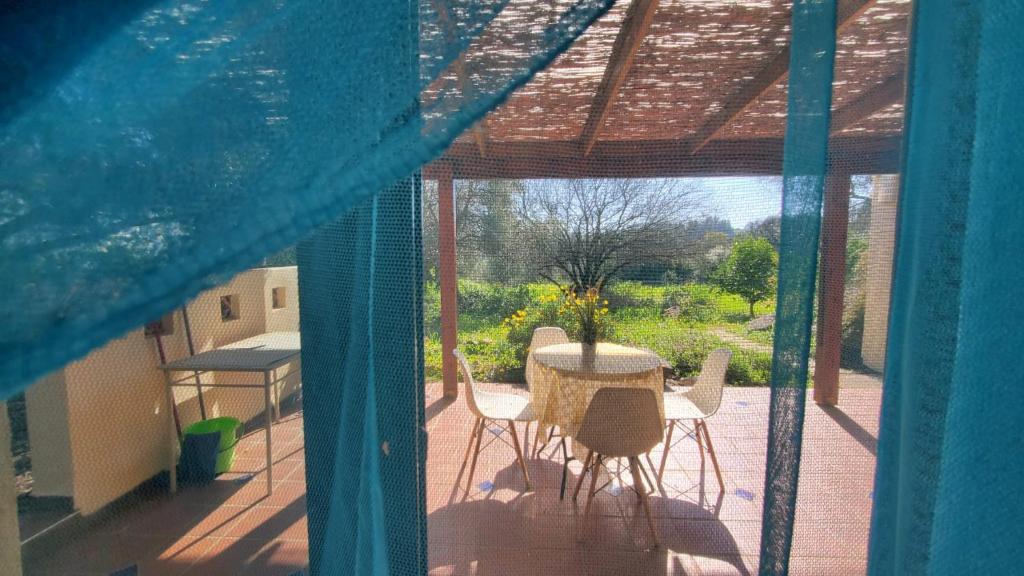 Blick auf eine Terrasse mit einem Tisch und Stühlen in der Unterkunft פינה ללב in Rosch Pina