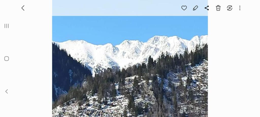 a picture of a mountain with snow on it at CASA FLOARE DE COLT in Sîmbăta de Sus